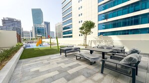 An outdoor patio area with seating and a small garden. - Vogue | VYB at Business Bay close to Downtown (Dubai)
