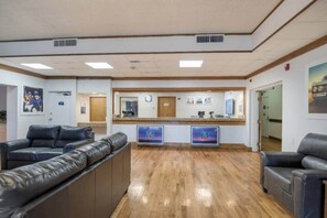 A reception area with a wooden floor, a reception desk, and two leather sofas. - 2 QUEEN BEDS | NON-SMOKING, KITCHEN (Colorado Springs)