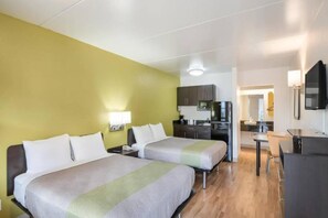 A hotel room with two beds, a kitchenette, and a TV. - 2 QUEEN BEDS | NON-SMOKING, KITCHEN (Colorado Springs)