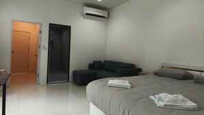 Une chambre moderne avec un grand lit, un canapé et un appareil de climatisation.