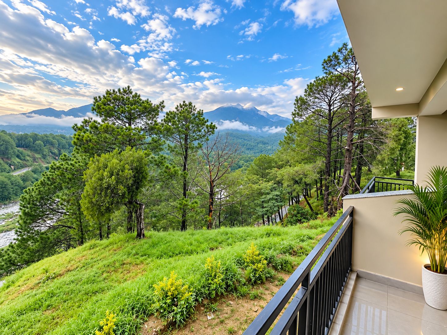 A balcony with a view of a mountainous landscape, lush greenery, and a river.