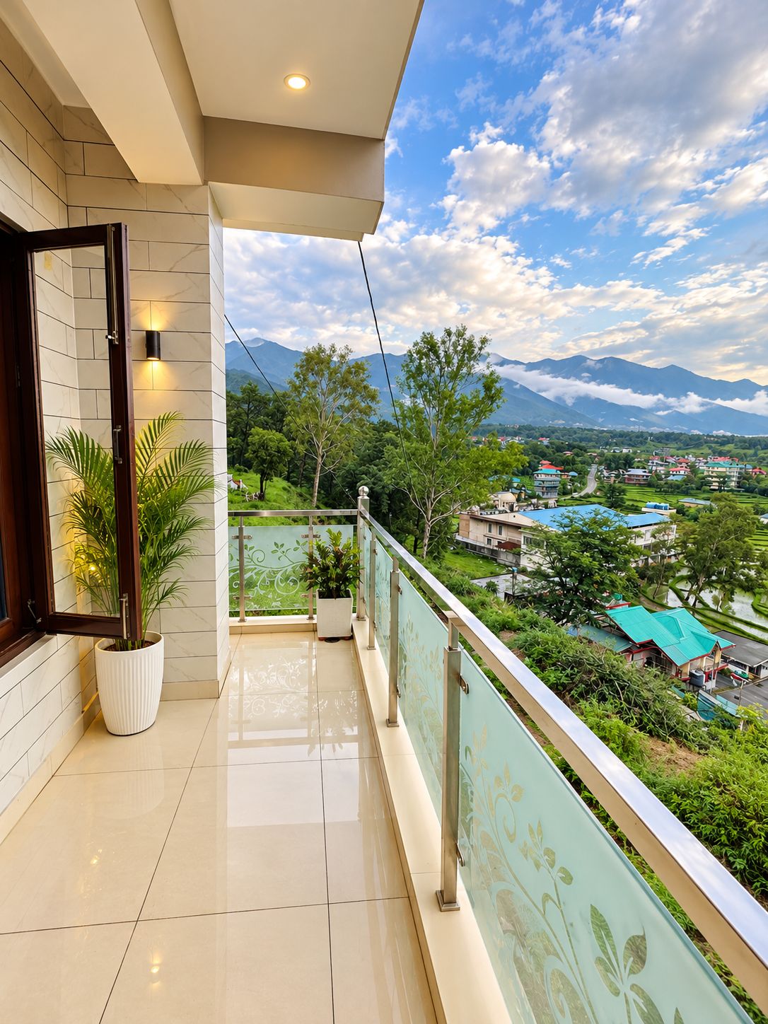 A balcony with a view of a mountainous landscape and a village below.
