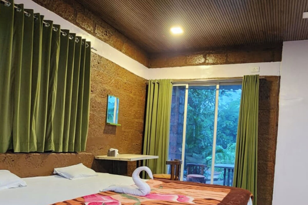 Habitación de hotel con una cama grande, una mesita y vistas al exterior.