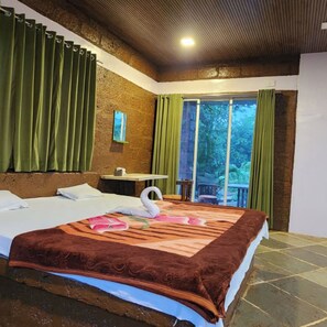 Habitación de hotel con una cama grande, una mesita y vistas al exterior.