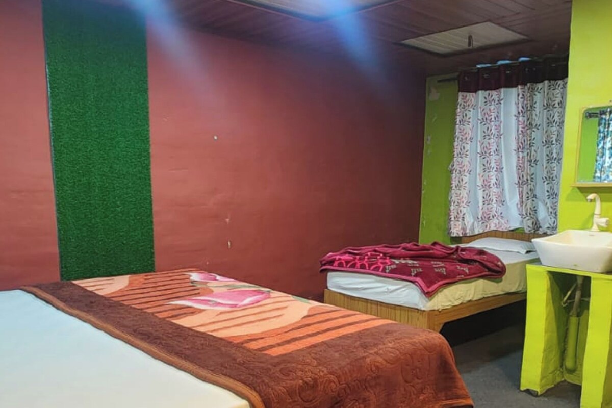 Una habitación con dos camas, un lavamanos y un espejo.