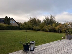 A wooden deck with a potted plant and a lantern. - 4 Star Holiday Home in Vejby (Vejby)