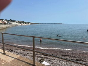 A coastal view with a pebble beach, a metal railing, and calm sea. - 2 Bedroom Villa, Sleeps 5, WiFi, Parking, Beach (Dawlish Warren)