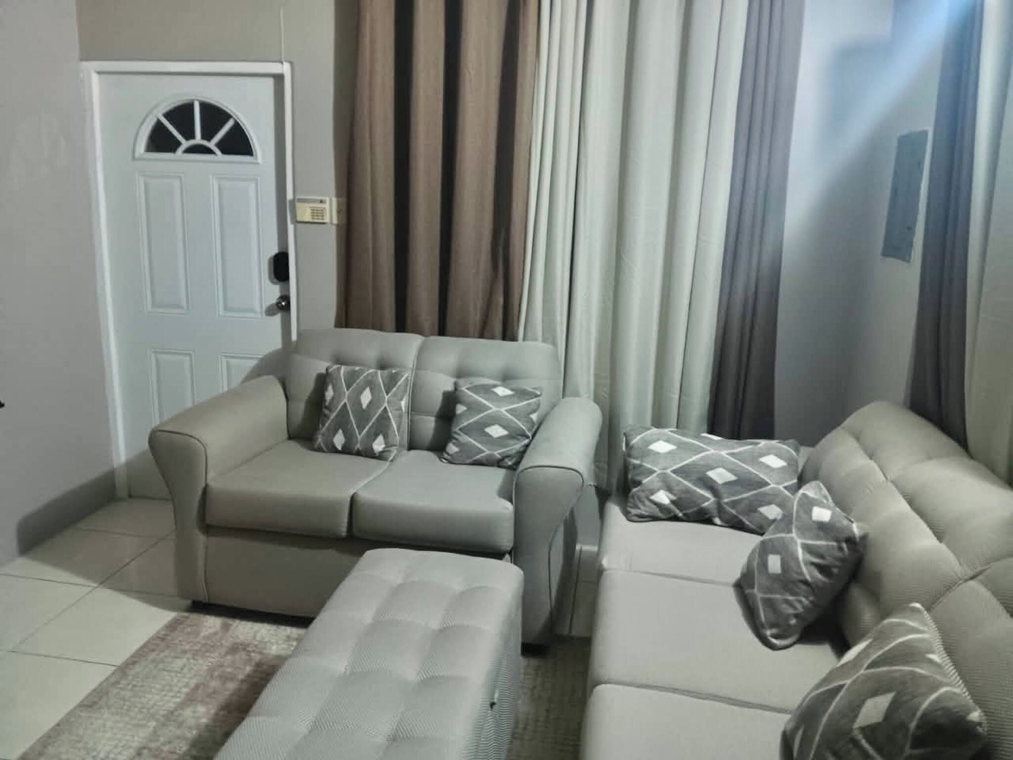 Una sala de estar con un sofá, una mesa de centro y una puerta con ventana.