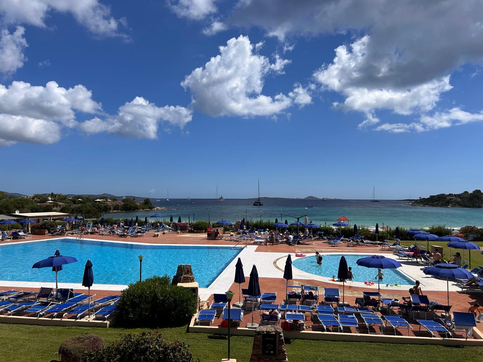 Un resort con diverse piscine, lettini e ombrelloni.