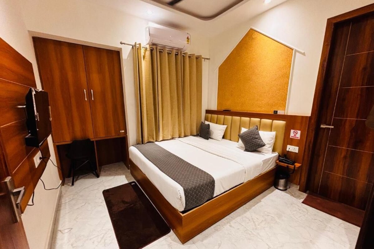 A bedroom with a bed, a desk, a wardrobe, and a bathroom.