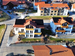 Ein Wohngebiet mit mehreren zweistöckigen Häusern, die rote Ziegeldächer und weiße Fassaden haben.