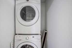 Eine gestapelte Waschmaschine und ein Trockner in einem Waschraum.