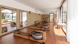 A spacious room with wooden flooring, large mirrors, and exercise equipment. - Domaine Du Mirage (Bormes-Les-Mimosas)