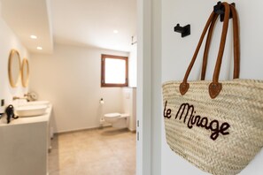 Un baño con un lavamanos blanco, un inodoro y una ventana.