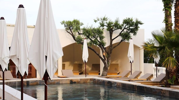 A poolside area with lounge chairs and umbrellas. - Domaine Du Mirage (Bormes-Les-Mimosas)