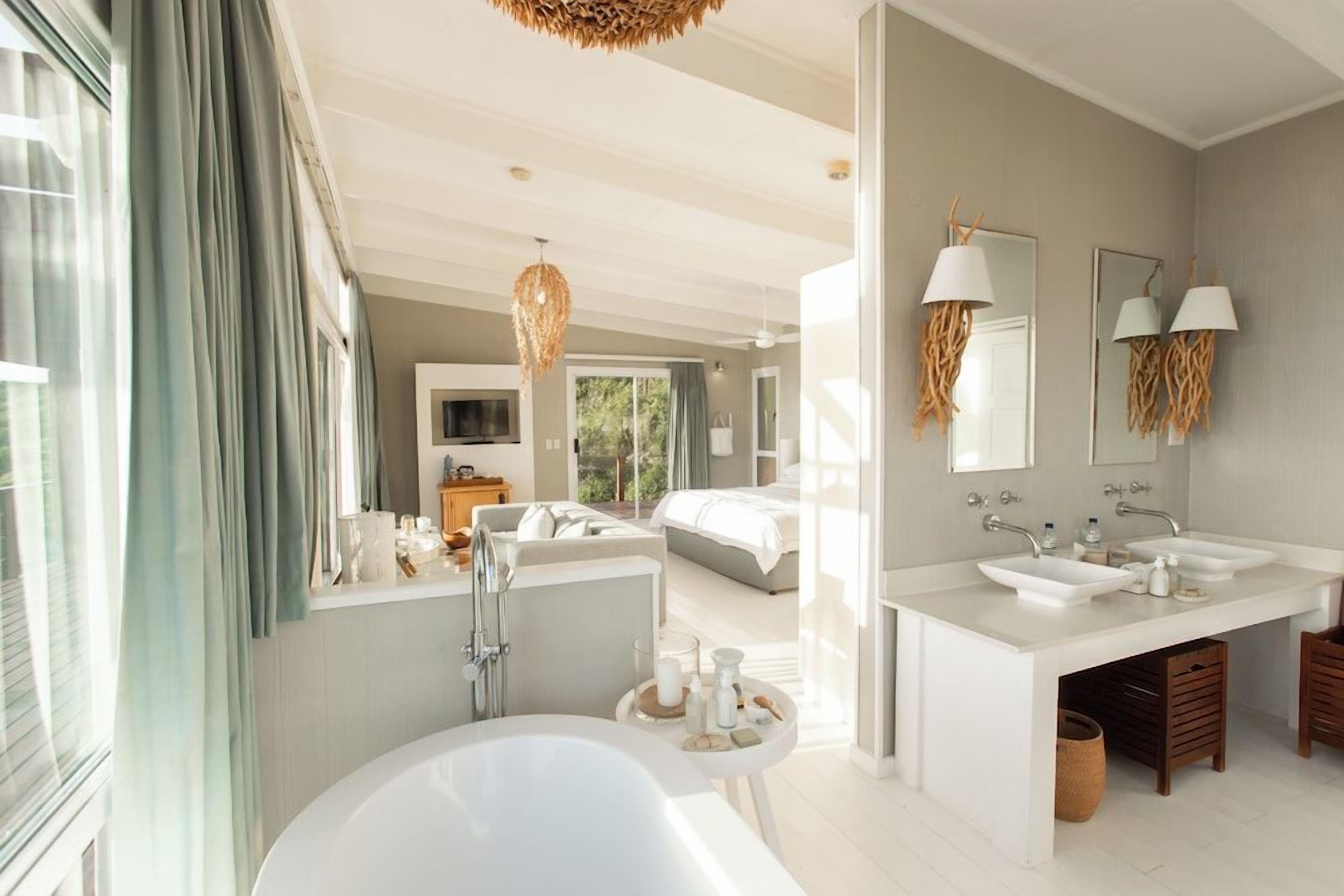 Ein modernes Badezimmer mit einer großzügigen Badewanne, zwei Waschbecken und einem Waschtisch.