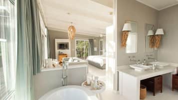 Ein modernes Badezimmer mit einer großzügigen Badewanne, zwei Waschbecken und einem Waschtisch.