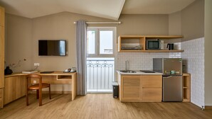 A compact kitchenette with a microwave, refrigerator, and a small sink. - Cubicity Nguyen Truong To (Ho Chi Minh)