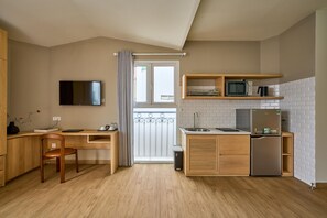 A compact kitchenette with a microwave, refrigerator, and a small sink. - Cubicity Nguyen Truong To (Ho Chi Minh)