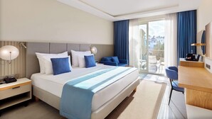 A hotel room with a bed, bedside tables, a desk, and a view of the outside. - Hydros Beach Resort (Kemer)