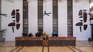 A reception desk with three computer stations, a ceiling fan, and vertical decorative panels. - Hydros Beach Resort (Kemer)