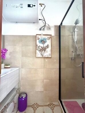 A bathroom with a shower, a toilet, a sink, and a towel rack. - Vacation rental sleeping 5 or 6 in the center of Marina di Ragusa. (Marina di Ragusa)