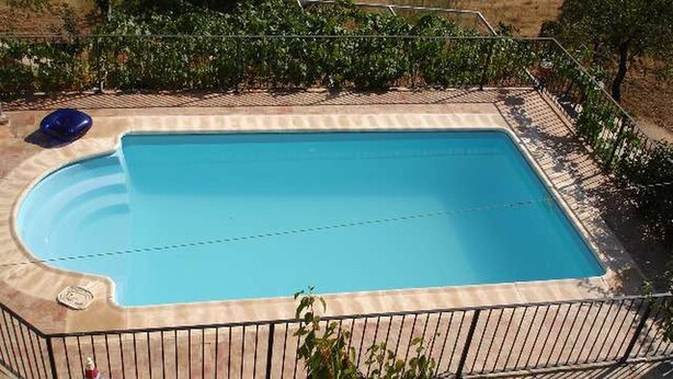 En rektangulær swimmingpool med en fliseparkettere rundt om.