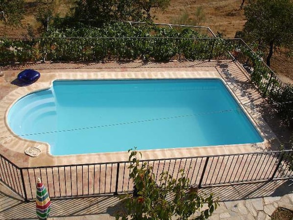 A rectangular swimming pool with a tiled deck surrounding it. - 6-guest Holiday Home in Central Laroya (Laroya)