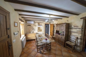 A rustic dining room with a glass table, wooden chairs, and a chandelier. - 6-guest Holiday Home in Central Laroya (Laroya)
