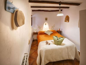 A bedroom with a bed, a nightstand, a lamp, and a wall-mounted hat rack. - 6-guest Holiday Home in Central Laroya (Laroya)