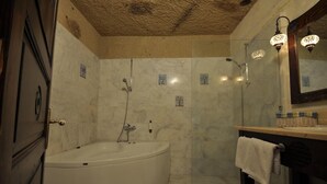 Un baño con una bañera independiente, ducha y tocador con espejo.