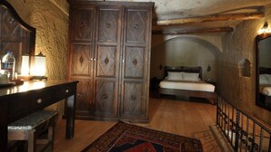 Un dormitorio con un armario de madera, una cama y un banco.