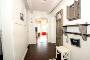 A hallway with a white bench, wooden door, and a chalkboard sign. - Seestern at Susanne-Fischer Weg 25 (Wyk auf Föhr)