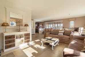 A spacious living area with a large sofa, a coffee table, and a white cabinet with drawers. - Holiday home in Borgsum with swimming pool (Borgsum)