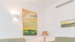 A room with two green sofas, a wooden coffee table, and two paintings on the walls. - Aldiana Club Andalusien (Chiclana de la Frontera)