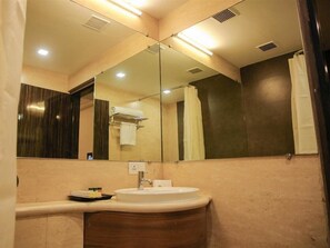 Une salle de bain équipée d’un lavabo, d’un miroir et d’un porte-serviettes.