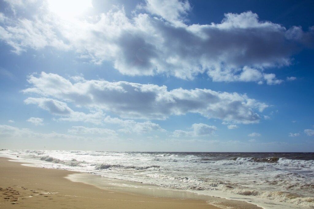 Uma praia com ondas e céu limpo.