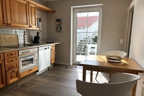 Eine Küche mit Holzausstattung, einer Arbeitsplatte, einem Herd und einem Geschirrspüler.