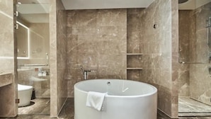 Ein modernes Badezimmer mit einer freistehenden Badewanne, einem Waschtisch mit Spiegel und einer Toilette.