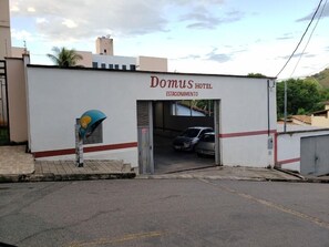 Un hotel llamado 'Domus Hotel' con un letrero que indica 'Estacionamiento'.