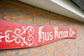 A red sign with white lettering on a brick wall. - Holiday bungalow Neßmersiel (Neßmersiel)