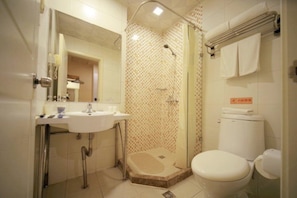 Un baño con ducha, inodoro y lavamanos.