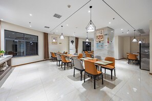 A modern dining area with multiple tables and chairs, recessed ceiling lighting, and a large window providing natural light. - City Convenient Hotel (Hengyang)