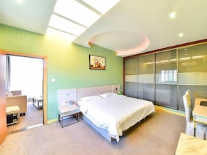 Habitació d'hotel moderna amb un llit gran, escriptori i porta corredissa de vidre cap a l'exterior.