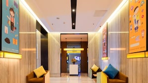 A hotel lobby with a reception desk, seating areas, and wooden paneling. - IU Hotel (Luoyang)