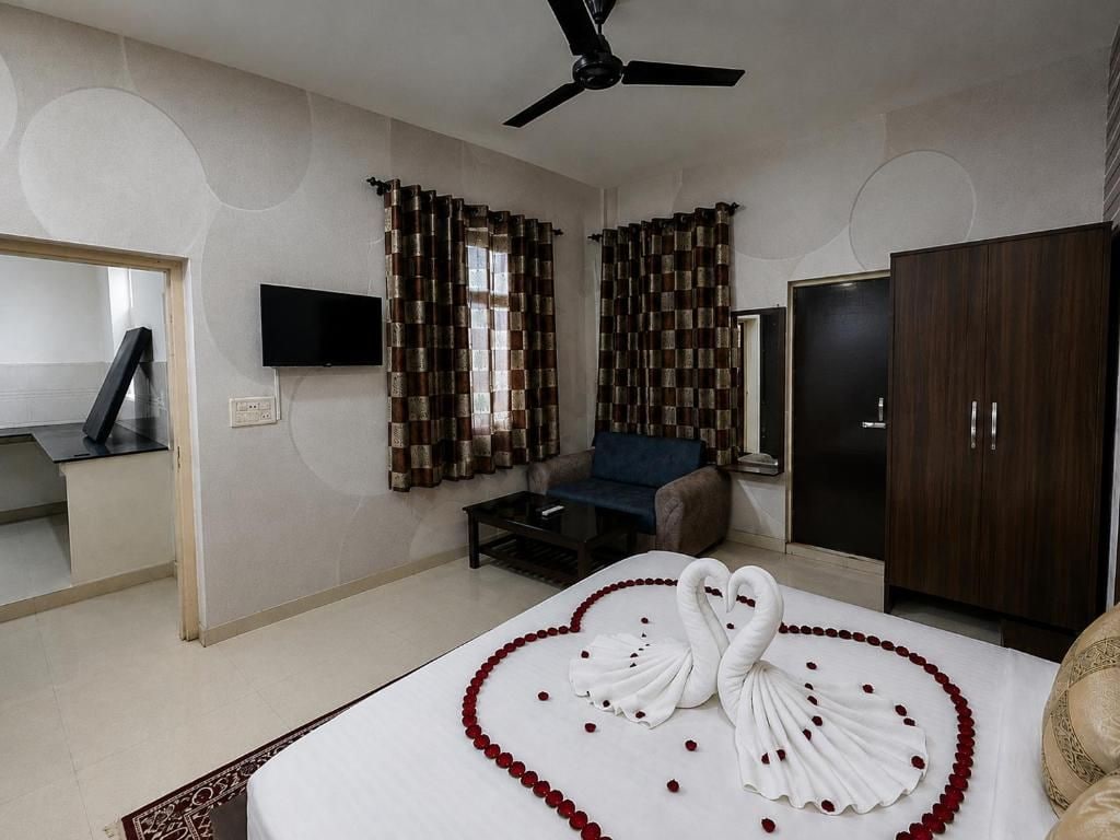 Una habitación de hotel con cama, televisión, sofá y armario.