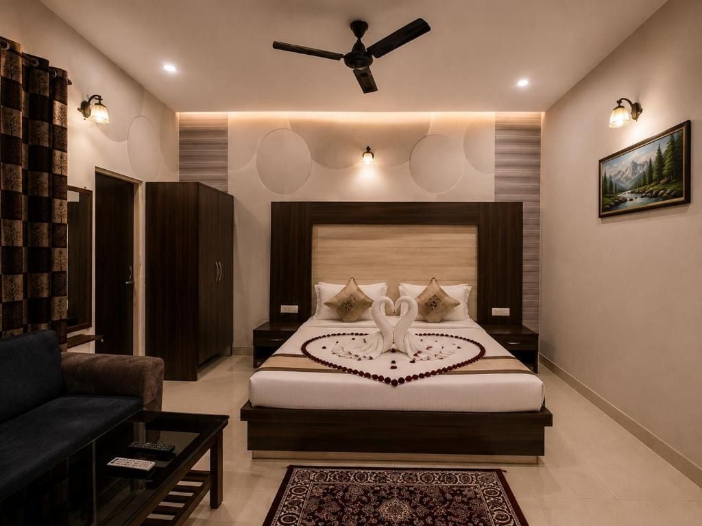 Un dormitorio con cama, ventilador de techo, mesita de noche, sofá y alfombra.