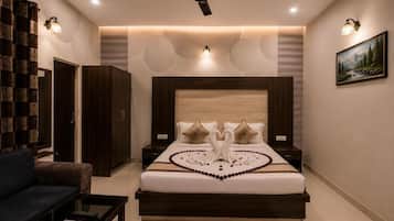 Un dormitorio con cama, ventilador de techo, mesita de noche, sofá y alfombra.