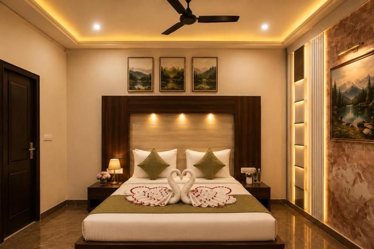 A hotel room with a large bed, a ceiling fan, and three framed pictures on the wall.