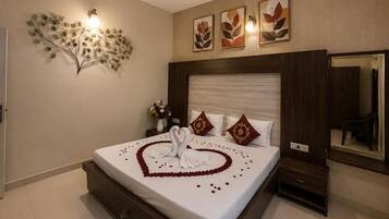Quarto de hotel com cama, luminária na parede e ventilador de teto.